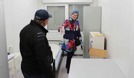 Manuela Heyns zeigt einem Obdachlosen die Ausstattung des Wohncontainers - Copyright: Julia Fischer
