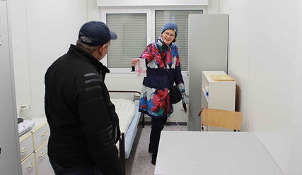 Manuela Heyns zeigt einem Obdachlosen die Ausstattung des Wohncontainers - Copyright: Julia Fischer