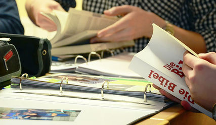Schulkinder mit einer Bibel im Unterricht - Copyright: © Creative Commons