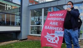 Vor dem Innenhof der Jugendherberge Horn posiert einer der Seeleute aus dem Pazifik mit einem Banner gegen Atomwaffen. - Copyright: © Hagen Grützmacher
