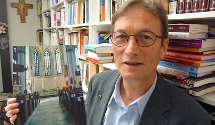 Gerade noch fertig geworden: Störmer mit einem Foto des neugestalteten Altarraums - Copyright: Sabine Henning/kirche-hamburg.de