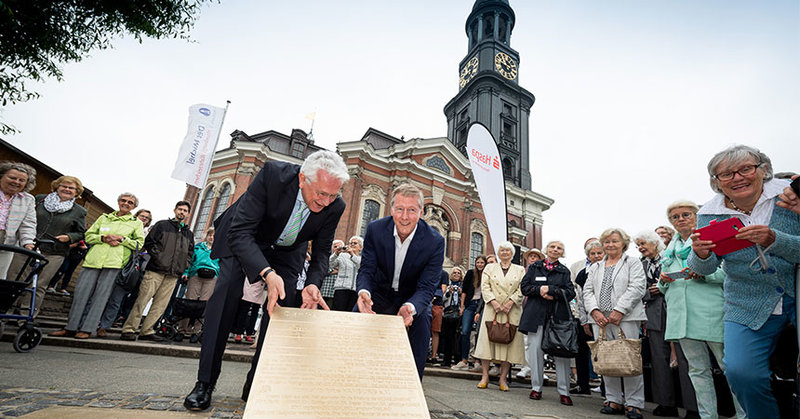 Hauptpastor Alexander Röder und Haspa-Vorstandssprecher Harald Vogelsang lassen eine neue Micheltafel in den Boden ein. - © R. Fuhrmann 