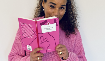 Das Bild zeigt Diana Dua mit ihrem Buch 'Zeilen gegen das Unbehagen' - Copyright: Diana Dua