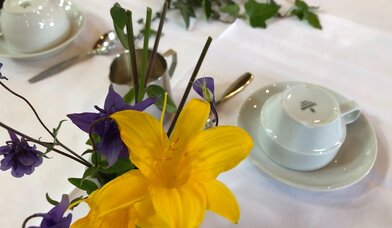 Ausschnitt Kaffeetafel: Umgedrehte Kaffeetassen und Blumenschmuck (Akelei und Taglilie) - Copyright: Carmen Mühlhause