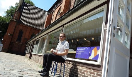 Sonnige Kaffeepause: Leiter Mark Möller vor dem „kirchencafé“