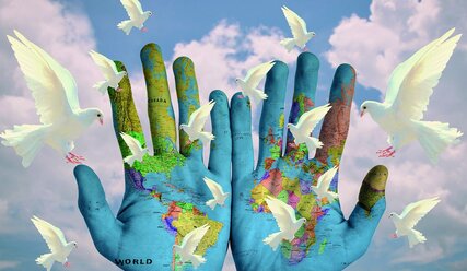 Handflächen mit aufgemalter Erdoberfläche und weißenTauben - Copyright: Pixabay