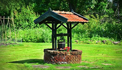 Brunnen im Garten mit hochgezogenem Eimer - Copyright: Mabel Amber, Pixabay