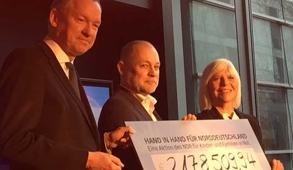 NDR Intendant Lutz Marmor (l.) und Elke Haferburg, Direktorin des NDR Landesfunkhauses Mecklenburg-Vorpommern und Vorsitzende der Projektgruppe für die Benefizaktion, übergeben symbolisch einen Scheck an Dirk Ahrens, Landespastor und Leiter des Diakonischen Werks Hamburg. - Copyright: Diakonisches Werk Hamburg