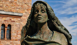 Die Statue einer Frau steht vor einem Gebäude - Copyright: Hans-Georg Vorndran / fundus-medien.de