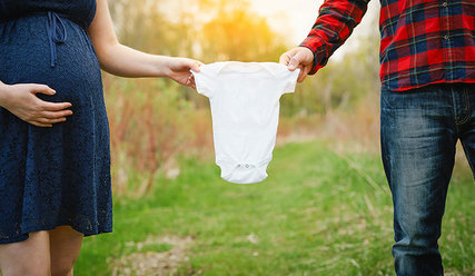 Schwangere Frau und ein Mann halten Babybody - Copyright: Unsplash