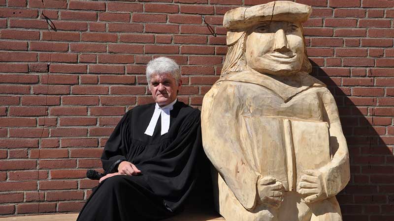 Pastor Andreas Petersen auf der Lutherbank vor "seiner" Kirche