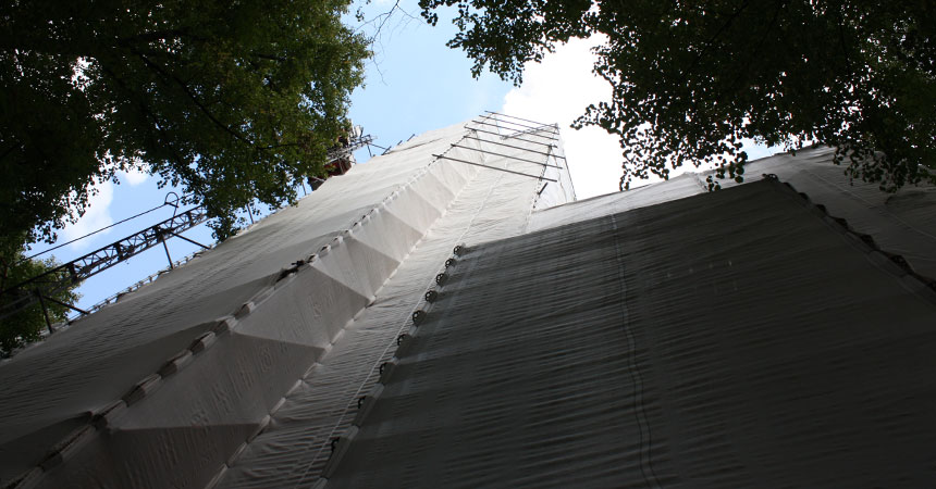 Von außen ist der Turm im Moment komplett eingerüstet. Die Bauarbeiten finden in schwindeliger Höhe statt.